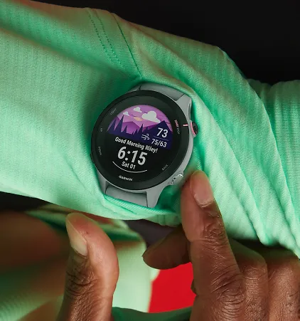 A person pressing a button on a Garmin watch